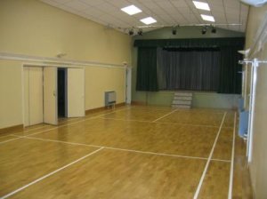 the photograph of the main hall shows the stage. The white lines delineating a badminton court have been removed. The doors on the left can be opened onto the small hall shown in the second photograph. The rooms may be hired independently of each other.